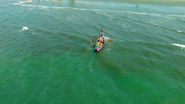 Aerial view of a vibrant boat slicing through the emerald waters near the sandy shore creating a stunning contrast of colors Cox s Bazar Chittagong Division Bangladesh. Aerial view of a vibrant boat slicing through the emerald waters near the sandy shore creating a stunning contrast of colors Cox s Bazar Chittagong Division Bangladesh.