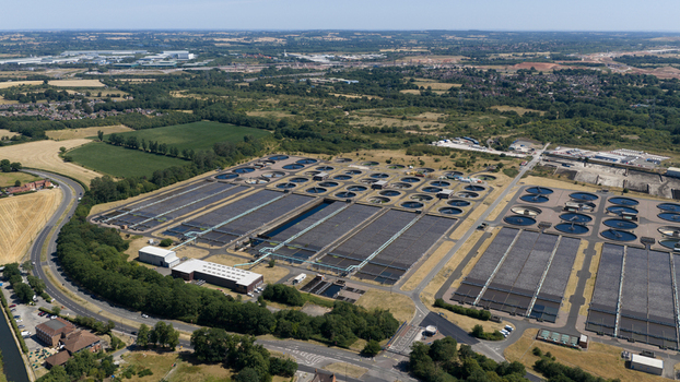 Aerial view of the Severn Trent Water Minworth wastewater treatment plant featuring circular tanks and rectangular treatment beds amidst green fields in Birmingham England United Kingdom. Aerial view of the Severn Trent Water Minworth wastewater treatment plant featuring circular tanks and rectangular treatment beds amidst green fields in Birmingham England United Kingdom.