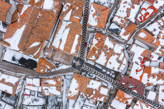 Aerial view of snow covered terracotta rooftops and narrow streets in Pescocostanzo Abruzzo Italy.