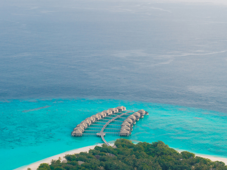 Aerial view of overwater bungalows stretching into the turquoise sea from a verdant island paradise Hoarafushi Thiladhunmathee Uthuruburi Maldives. Aerial view of overwater bungalows stretching into the turquoise sea from a verdant island paradise Hoarafushi Thiladhunmathee Uthuruburi Maldives.