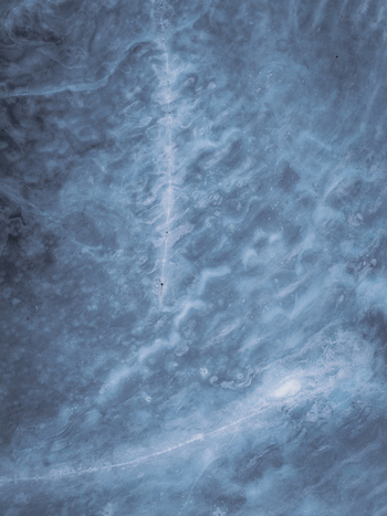 Aerial view of the stark icy landscape with delicate patterns etched by wind and snow Tind Nordland Norway.