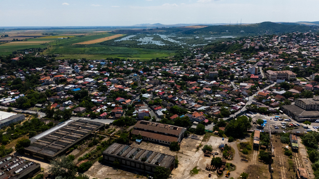 Aerial view of the city of Tulcea featuring dense residential rooftops industrial structures and surrounding wetlands in Tulcea Tulcea Romania. Aerial view of the city of Tulcea featuring dense residential rooftops industrial structures and surrounding wetlands in Tulcea Tulcea Romania.