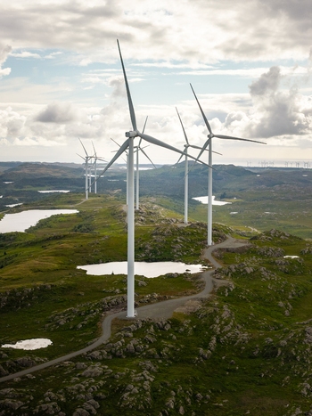 Aerial view of Makaknuten Vindkraftverk wind turbines set amidst rolling green hills small lakes and a gravel access road in Bjerkreim Municipality Rogaland Norway. Aerial view of Makaknuten Vindkraftverk wind turbines set amidst rolling green hills small lakes and a gravel access road in Bjerkreim Municipality Rogaland Norway.