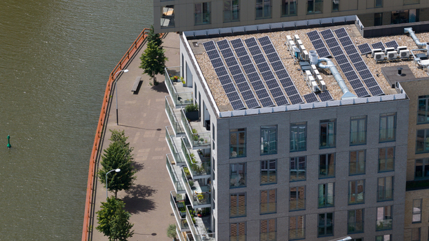 Aerial view of the modern apartment building on Cruquiusweg featuring rooftop solar panels and balconies situated along the waterfront in Amsterdam Noord Holland Netherlands.