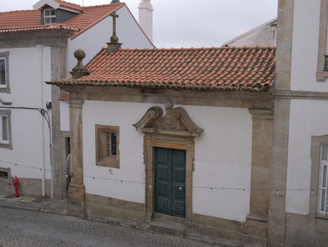 View of a small historic chapel with a stone doorway and terracotta roof in the streets of Covilha Castelo Branco District Portugal.