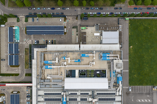 Aerial view of a modern industrial facility featuring rooftop solar panels and complex HVAC ventilation systems San Giovanni Valdarno Tuscany Italy.