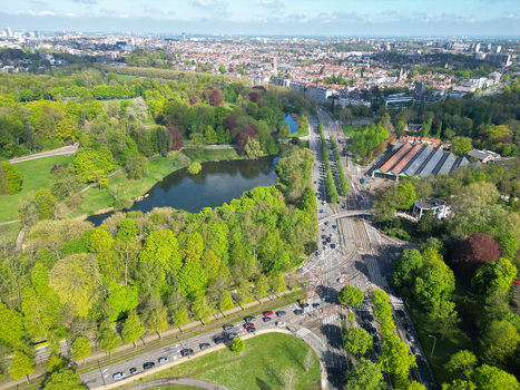 Aerial view of a lush green park with a serene lake and busy urban roads under a clear sky in Woluwe Saint Pierre Bruxelles Belgium. Aerial view of a lush green park with a serene lake and busy urban roads under a clear sky in Woluwe Saint Pierre Bruxelles Belgium.