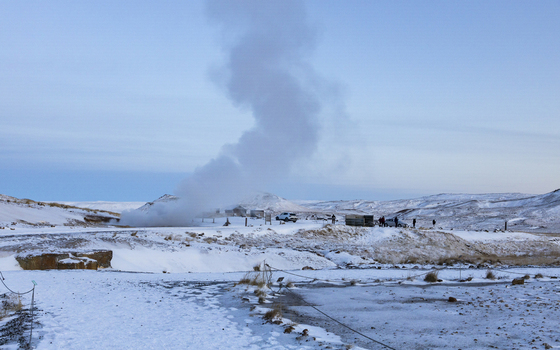 View of geothermal steam billowing above the snowy landscape contrasting with the cold sky in Selt&uacute;n Geothermal Area Hafnarfjar&eth;arkaupsta&eth;ur Iceland.