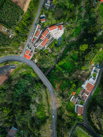 Aerial view of terracotta roofs and verdant foliage meet the winding roads in a vibrant tapestry of urban and natural harmony Agua de Alto Azores Portugal.