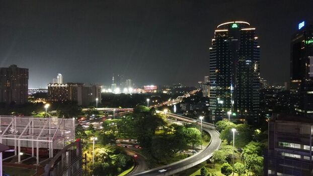 Aerial view of the illuminated Semanggi Interchange with traffic light trails and surrounding skyscrapers at night in Kecamatan Setiabudi Daerah Khusus Ibukota Indonesia. Aerial view of the illuminated Semanggi Interchange with traffic light trails and surrounding skyscrapers at night in Kecamatan Setiabudi Daerah Khusus Ibukota Indonesia.