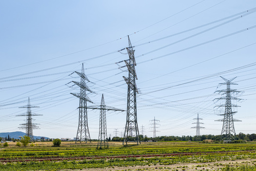 Aerial view of Amprion Umspannwerk with high voltage electricity pylons and power lines stretching across agricultural fields Pfungstadt Hessen Germany.