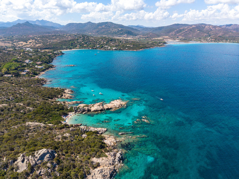 Aerial view of the turquoise waters and rocky coastline of San Teodoro with Mediterranean vegetation and boats in the bay San Teodoro Sardegna Italy.