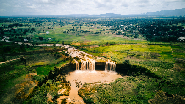 Aerial view of Matsirga Waterfalls cascading into a river surrounded by lush green agricultural fields and rural landscape in Madakiya Kaduna Nigeria. Aerial view of Matsirga Waterfalls cascading into a river surrounded by lush green agricultural fields and rural landscape in Madakiya Kaduna Nigeria.