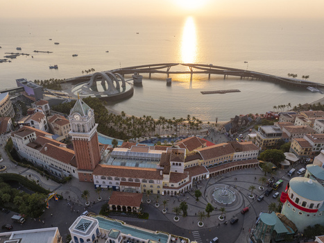 Aerial view of the Mediterranean style town with its iconic clock tower and the Kiss Bridge stretching over the sea at sunset in Phu Quoc An Giang Vietnam. Aerial view of the Mediterranean style town with its iconic clock tower and the Kiss Bridge stretching over the sea at sunset in Phu Quoc An Giang Vietnam.