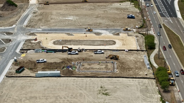 Aerial view of Foundry Lane construction site with heavy machinery workers and dirt ground in World Golf Village Florida United States.
