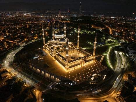Aerial view of Grand Camlica Mosque illuminated at night surrounded by the sprawling city lights of Uskudar Istanbul Turkiye. Aerial view of Grand Camlica Mosque illuminated at night surrounded by the sprawling city lights of Uskudar Istanbul Turkiye.
