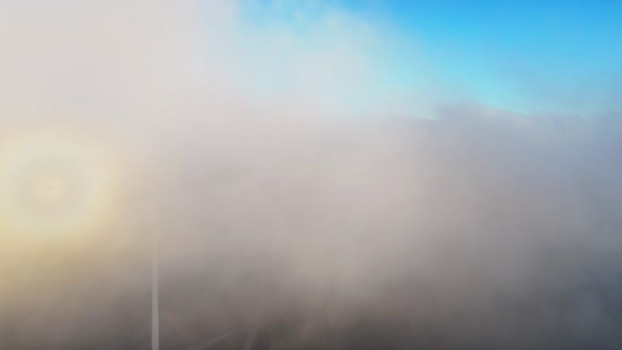 Aerial view of Windpark Freilanderalm turbines in clouds Austria.