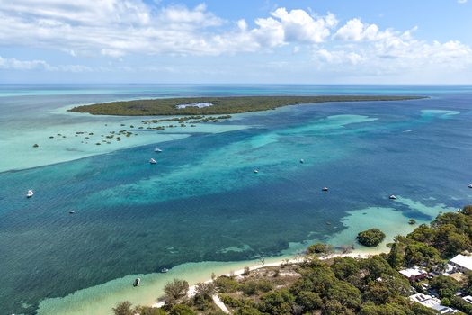 Aerial view of Moreton Island with turquoise waters sandy coastline scattered boats and lush vegetation in Kooringal Queensland Australia. Aerial view of Moreton Island with turquoise waters sandy coastline scattered boats and lush vegetation in Kooringal Queensland Australia.