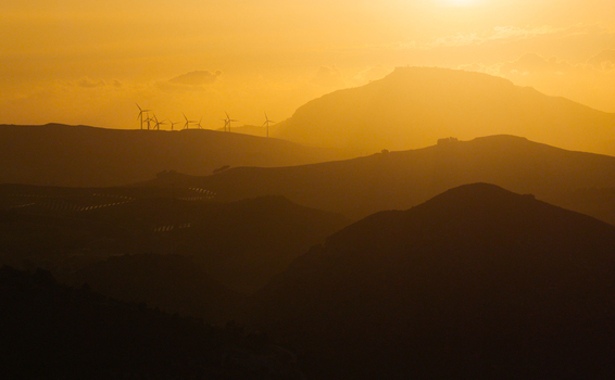 Aerial view of Riserva Naturale Orientata dello Zingaro with wind turbines on rolling hills at sunset in San Vito Lo Capo Sicilia Italy. Aerial view of Riserva Naturale Orientata dello Zingaro with wind turbines on rolling hills at sunset in San Vito Lo Capo Sicilia Italy.