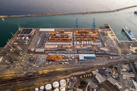 Civitavecchia Italy 22 August 2026 Aerial view of Civitavecchia Port with container terminals cargo cranes parked vehicles and industrial infrastructure along the coast.