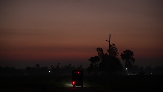 View of a rickshaw driving at dusk in Bogura Bangladesh. View of a rickshaw driving at dusk in Bogura Bangladesh.