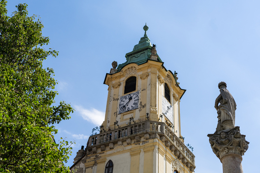 View of the historic Old Town Hall clock tower and the Maximilian Fountain statue under a clear blue sky in Bratislava Bratislava Region Slovakia. View of the historic Old Town Hall clock tower and the Maximilian Fountain statue under a clear blue sky in Bratislava Bratislava Region Slovakia.