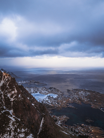 Aerial view of the rugged coastline meeting the vast ocean under a dramatic sky Leknes Nordland Norway.