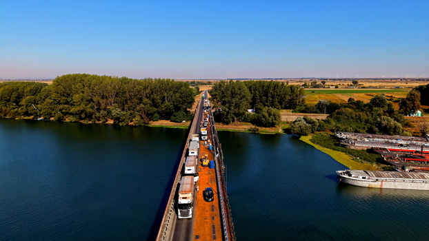 Aerial view of Smederevo bridge crossing the river with traffic and an adjacent shipyard with moored barges in Smederevo Podunavlje District Serbia.