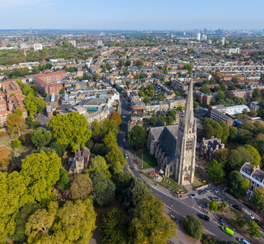 Aerial view of St Mary s Church in Stoke Newington surrounded by lush green trees and historic residential architecture in London England United Kingdom. Aerial view of St Mary s Church in Stoke Newington surrounded by lush green trees and historic residential architecture in London England United Kingdom.