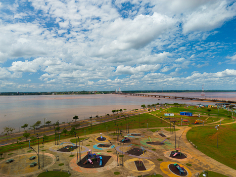 Aerial view of the waterfront park with playground equipment and the San Roque Gonzalez de Santa Cruz bridge spanning the Parana River in Posadas Misiones Province Argentina. Aerial view of the waterfront park with playground equipment and the San Roque Gonzalez de Santa Cruz bridge spanning the Parana River in Posadas Misiones Province Argentina.
