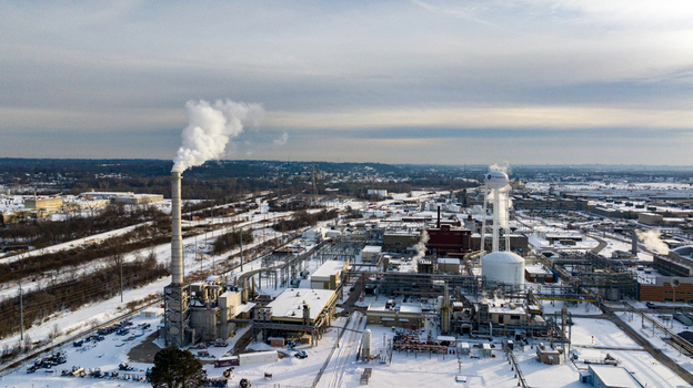 Aerial view of the GE Aerospace industrial complex with smoking chimneys and snow covered rooftops in Reading Ohio United States. Aerial view of the GE Aerospace industrial complex with smoking chimneys and snow covered rooftops in Reading Ohio United States.
