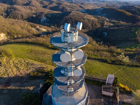 Aerial view of the Television Tower Tortona with its satellite dishes overlooking the rolling hills and green landscape of Tortona Piedmont Italy.