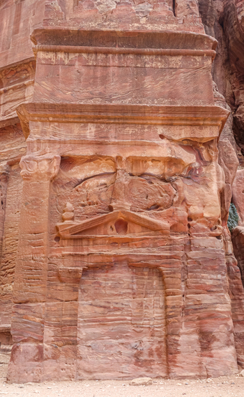View of the intricate rock cut facade of an ancient Nabataean tomb carved into the sandstone cliffs of Petra in Wadi Musa Ma an Governorate Jordan. View of the intricate rock cut facade of an ancient Nabataean tomb carved into the sandstone cliffs of Petra in Wadi Musa Ma an Governorate Jordan.