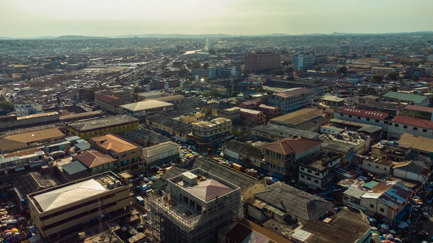 Accra Ghana 26 May 2023 Aerial view of the dense urban landscape of Accra featuring a mix of commercial buildings residential rooftops and bustling market streets under a hazy sky. Accra Ghana 26 May 2023 Aerial view of the dense urban landscape of Accra featuring a mix of commercial buildings residential rooftops and bustling market streets under a hazy sky.