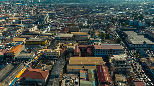 Accra Ghana 26 May 2023 Aerial view of the dense urban landscape of Accra featuring a mix of commercial buildings residential rooftops and busy market streets under a clear sky. Accra Ghana 26 May 2023 Aerial view of the dense urban landscape of Accra featuring a mix of commercial buildings residential rooftops and busy market streets under a clear sky.