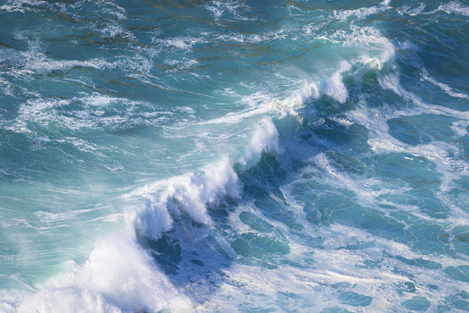 View of crashing turquoise waves and white sea foam at Silence Beach Asturias Asturias Spain.