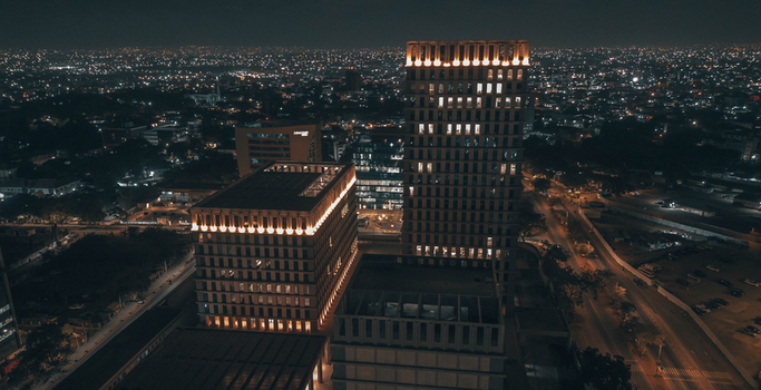 Aerial view of The Bank Square illuminated at night with modern architectural facades and surrounding city lights in Accra Greater Accra Region Ghana.