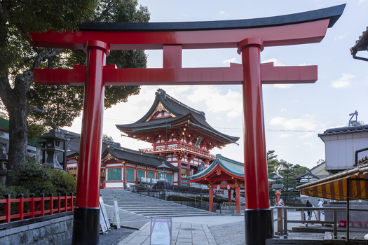 View of the grand red torii gate and the Romon gate at Fushimi Inari taisha Shinto shrine under a clear sky Kyoto Kyoto Japan.