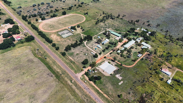 Aerial view of Alma featuring a running track sports fields and rural buildings surrounded by green bushveld in Waterberg District Municipality Limpopo South Africa. Aerial view of Alma featuring a running track sports fields and rural buildings surrounded by green bushveld in Waterberg District Municipality Limpopo South Africa.