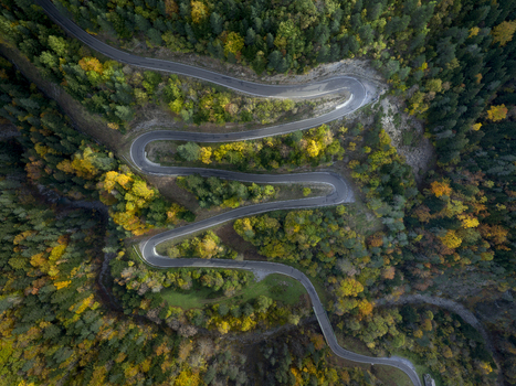 Aerial view of a winding mountain road through the Pyrenees forest with vibrant autumn foliage in Spain. Aerial view of a winding mountain road through the Pyrenees forest with vibrant autumn foliage in Spain.