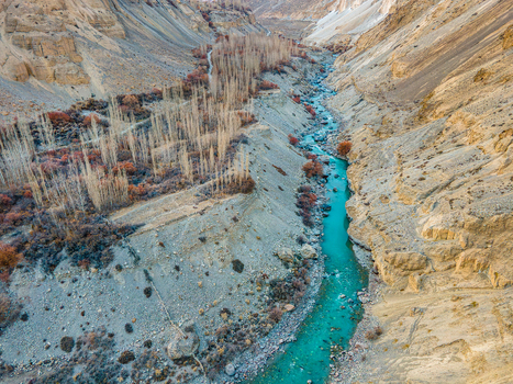 Aerial view of turquoise river snaking through a rugged rocky canyon its waters a stark contrast to the arid landscape Hunza Nagar Gilgit Pakistan. Aerial view of turquoise river snaking through a rugged rocky canyon its waters a stark contrast to the arid landscape Hunza Nagar Gilgit Pakistan.