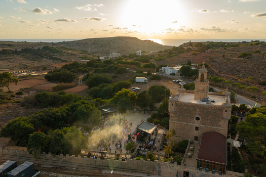 Mgarr Northern Region Malta 17 September 2026 Aerial view of Castello Zamittello during an outdoor event at sunset with guests in the courtyard and the Mediterranean Sea. Mgarr Northern Region Malta 17 September 2026 Aerial view of Castello Zamittello during an outdoor event at sunset with guests in the courtyard and the Mediterranean Sea.