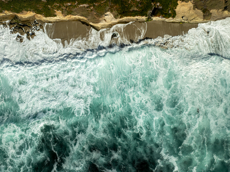 Aerial view of turquoise waves crashing against the sandy shore and rugged cliffs of La Jolla Cove in San Diego California United States. Aerial view of turquoise waves crashing against the sandy shore and rugged cliffs of La Jolla Cove in San Diego California United States.