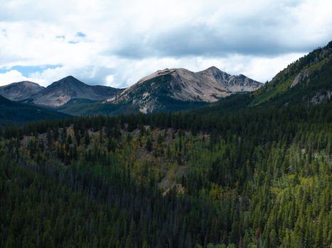 Aerial view of Mount Harvard surrounded by dense pine forests and rugged mountain peaks under a cloudy sky in Buena Vista Colorado United States. Aerial view of Mount Harvard surrounded by dense pine forests and rugged mountain peaks under a cloudy sky in Buena Vista Colorado United States.