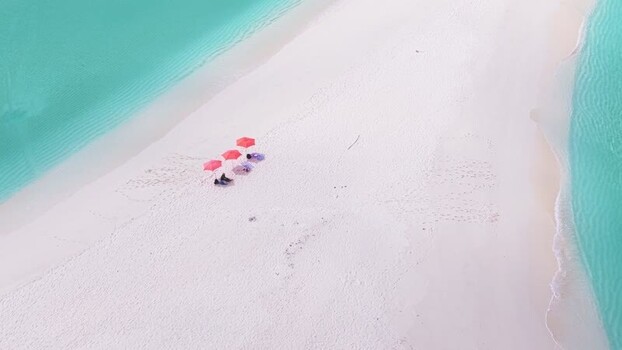 Aerial view of red umbrellas on a white sandbar in the Maldives. Aerial view of red umbrellas on a white sandbar in the Maldives.