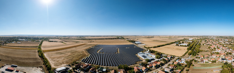 Aerial view of a large solar farm with rows of photovoltaic panels situated amidst agricultural fields and residential areas in Temerin Vojvodina Serbia. Aerial view of a large solar farm with rows of photovoltaic panels situated amidst agricultural fields and residential areas in Temerin Vojvodina Serbia.