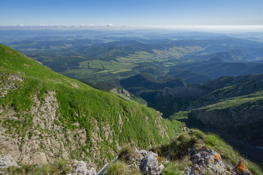 View of the Zdiarska vidla peak in the Belianske Tatry mountains with lush green slopes and a vast valley under a clear blue sky in Zdiar Presov Region Slovakia. View of the Zdiarska vidla peak in the Belianske Tatry mountains with lush green slopes and a vast valley under a clear blue sky in Zdiar Presov Region Slovakia.