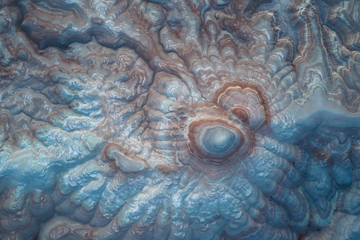 Aerial view of the textured layered earth sculpted by time and elements reveals a tapestry of pale blues and rusty browns Hanksville Utah United States. Aerial view of the textured layered earth sculpted by time and elements reveals a tapestry of pale blues and rusty browns Hanksville Utah United States.