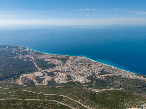Aerial view of the winding roads of Llogara Pass overlooking the turquoise Ionian Sea and coastal developments in Llogara Vlore County Albania. Aerial view of the winding roads of Llogara Pass overlooking the turquoise Ionian Sea and coastal developments in Llogara Vlore County Albania.