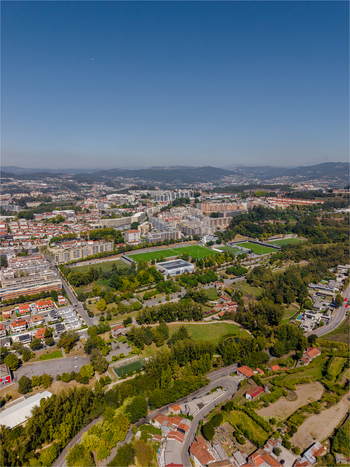 Aerial view of the urban landscape of Guimaraes featuring residential buildings green parks and sports fields under a clear blue sky in Guimaraes Braga Portugal. Aerial view of the urban landscape of Guimaraes featuring residential buildings green parks and sports fields under a clear blue sky in Guimaraes Braga Portugal.
